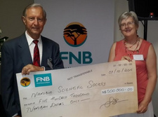 Namibia Wissenschaftliche Gesellschaft möchte riesige Privatsammlung erwerben. Jane Katjavivi, Vorsitzende der FNB-Stiftung, überreicht einen Scheck über 500000 Namibia-Dollar an den NWG-Vizepräsidenten Helmut Bistri. Foto: Stefan Fischer.